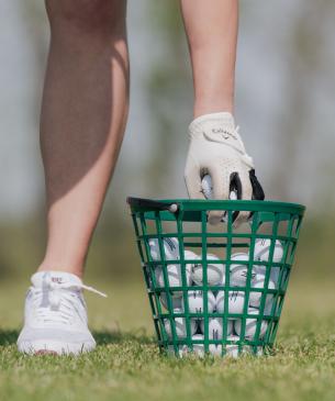 man reaching for golf ball